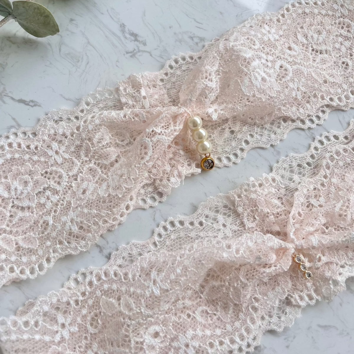 Elegantes Strumpfband aus blush Spitze mit funkelnden Strasssteinchen.