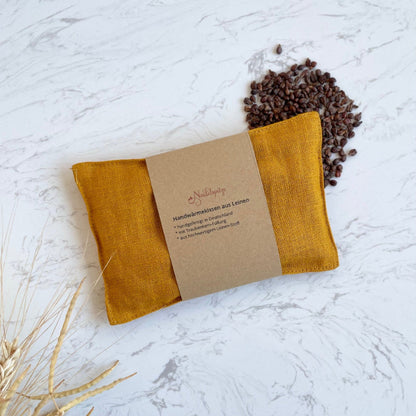 Handwaermekissen aus Leinen mit Traubenkernen gefüllt und Banderole als Geschenk verpackt