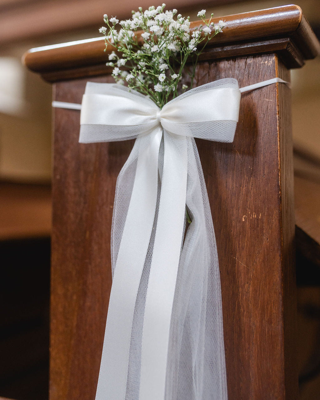 Detailaufnahme der Kirchenbankschleife mit Tüll und Satinband