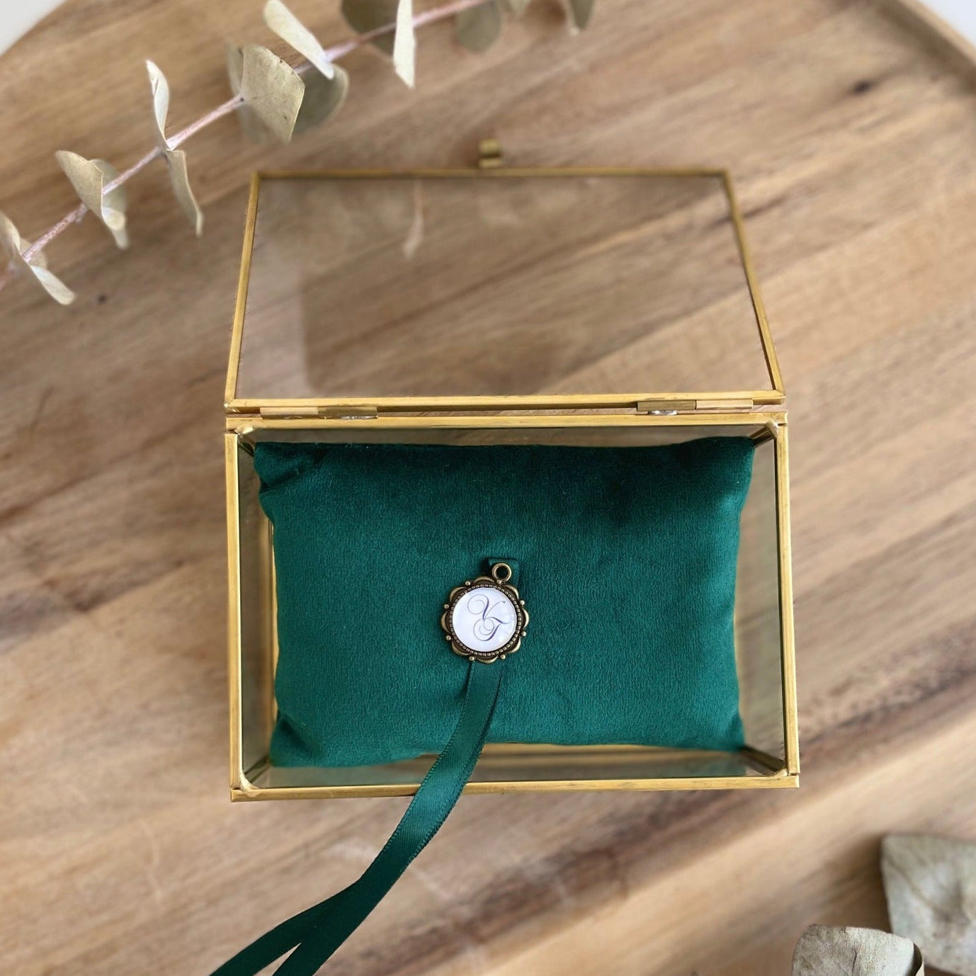Ringkästchen aus Glas mit goldfarbenem Rand und smaragdgrünem Samtkissen für die Hochzeit