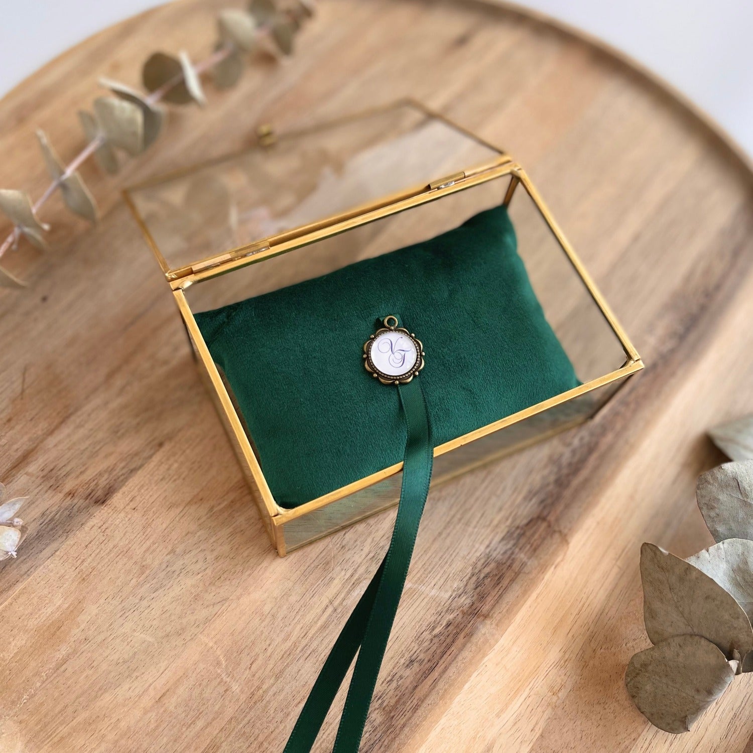 Ringbox aus Glas mit goldfarbener Kante und smaragdgrünem Ringkissen für die Hochzeit