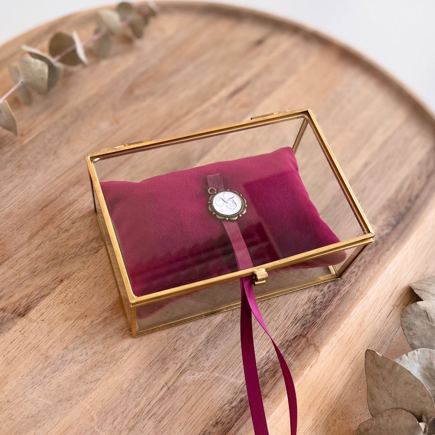 Ringbox aus Glas mit goldfarbener Kante und rubinrotem Samtkissen zur Hochzeit