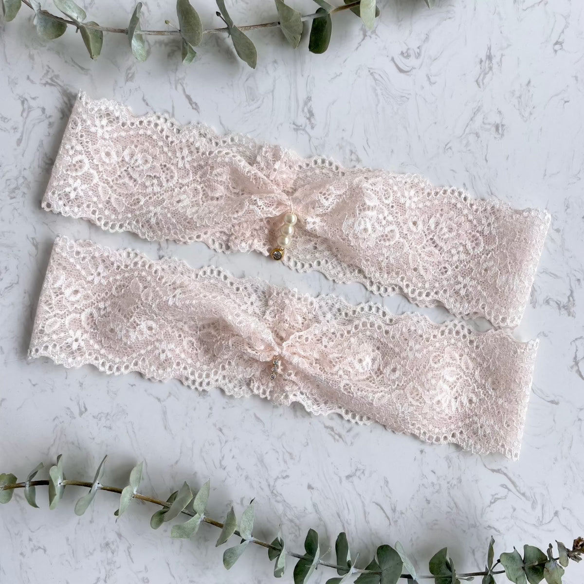 Zartes Strumpfband aus blushfarbener Spitze mit edlen Perlen zur Hochzeit.