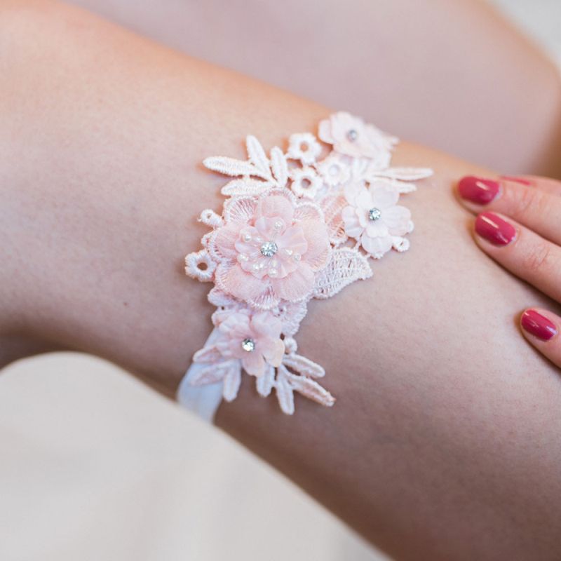 Zartes Strumpfband in Peach für ein romantisches Brautoutfit.