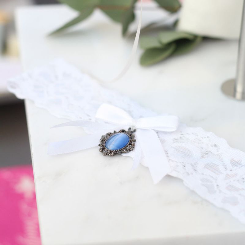 Strumpfband in Ivory mit blauem Stein als traditionelles Accessoire.