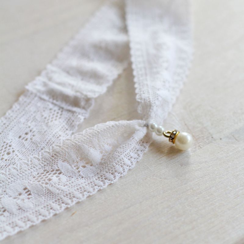 Elegantes Strumpfband mit edler Perle als Hochzeitsaccessoire.